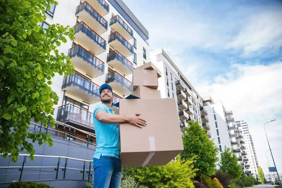 Man carrying boxes outside an apartment building during a move